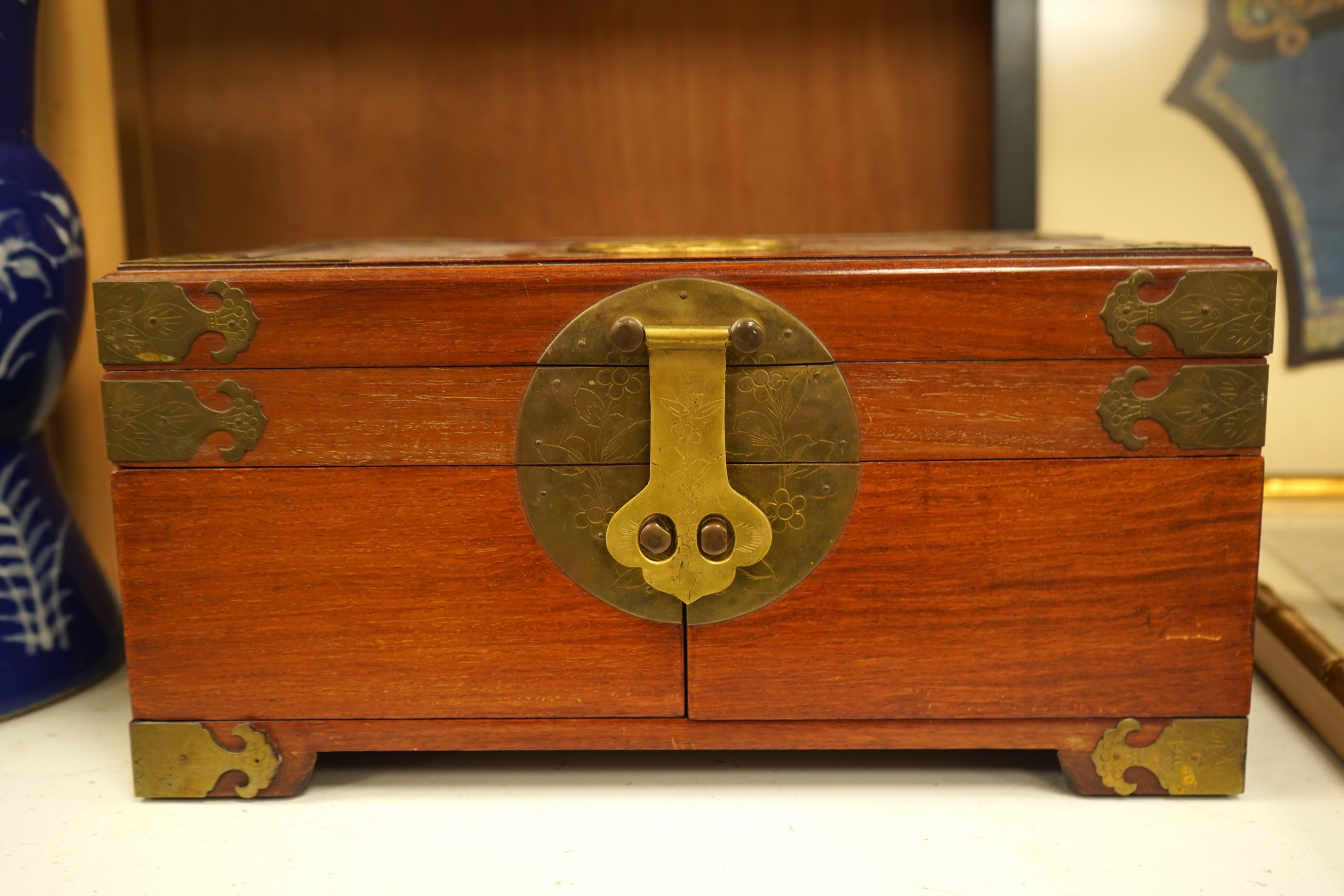 A Chinese brass bound rosewood jewellery box with twin handles, the interior with sewing accessories and threads, 35cm wide